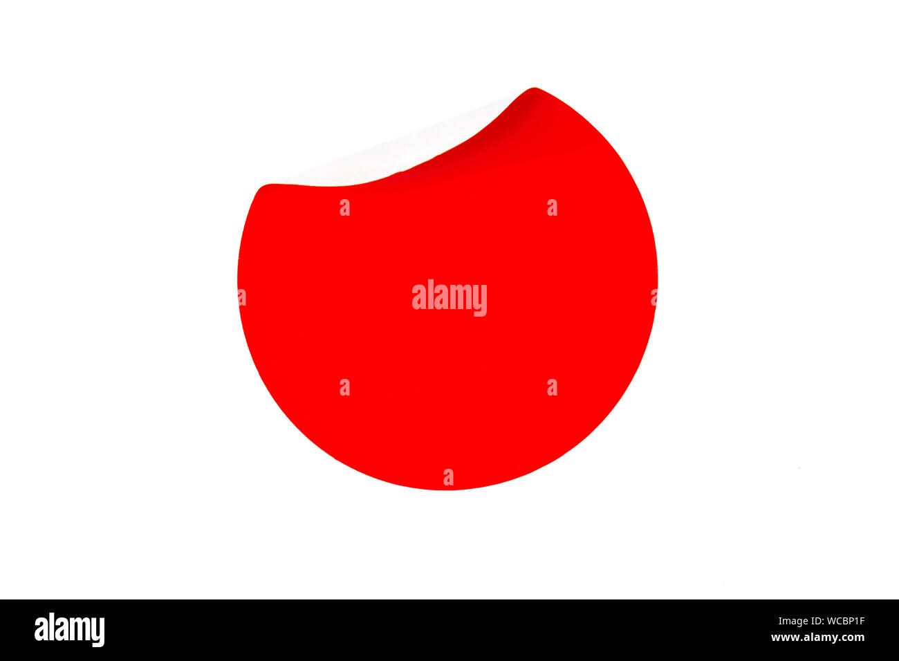 Uno sbozzato adesivo rosso con lato arricciata su uno sfondo bianco con posto per il testo. Vista da sopra. Isolato. Foto Stock