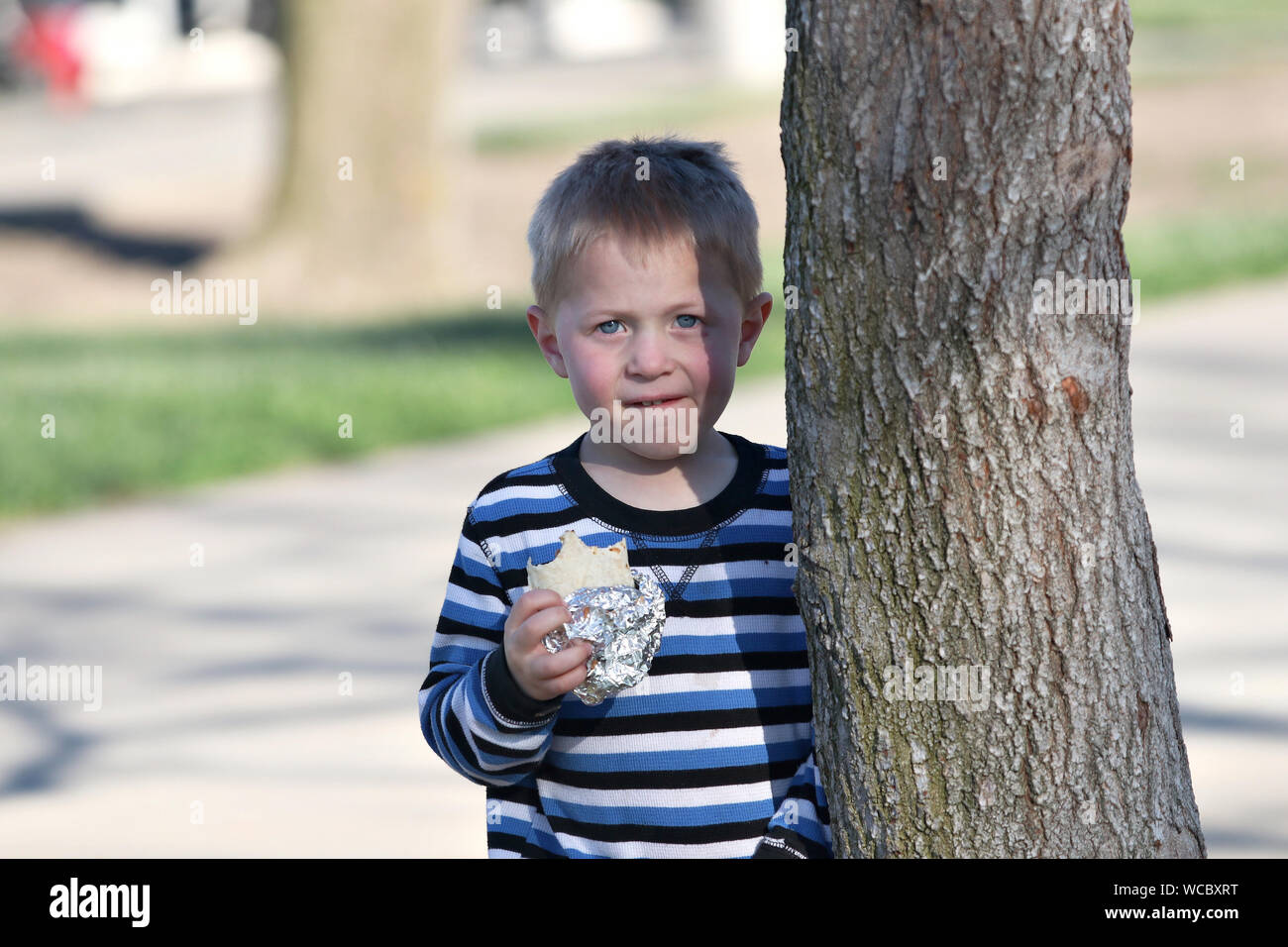 Ragazzo di intrufolarsi un burrito dalla tabella di nascosto. Foto Stock