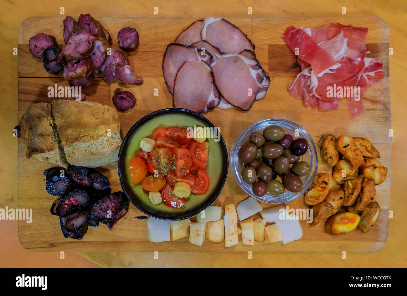 Consiglio di tradizionale cucina portoghese con il sangue e la salsiccia di maiale, prosciutto, pane, formaggio, insalata di pomodoro e olive in un ristorante di porto Foto Stock