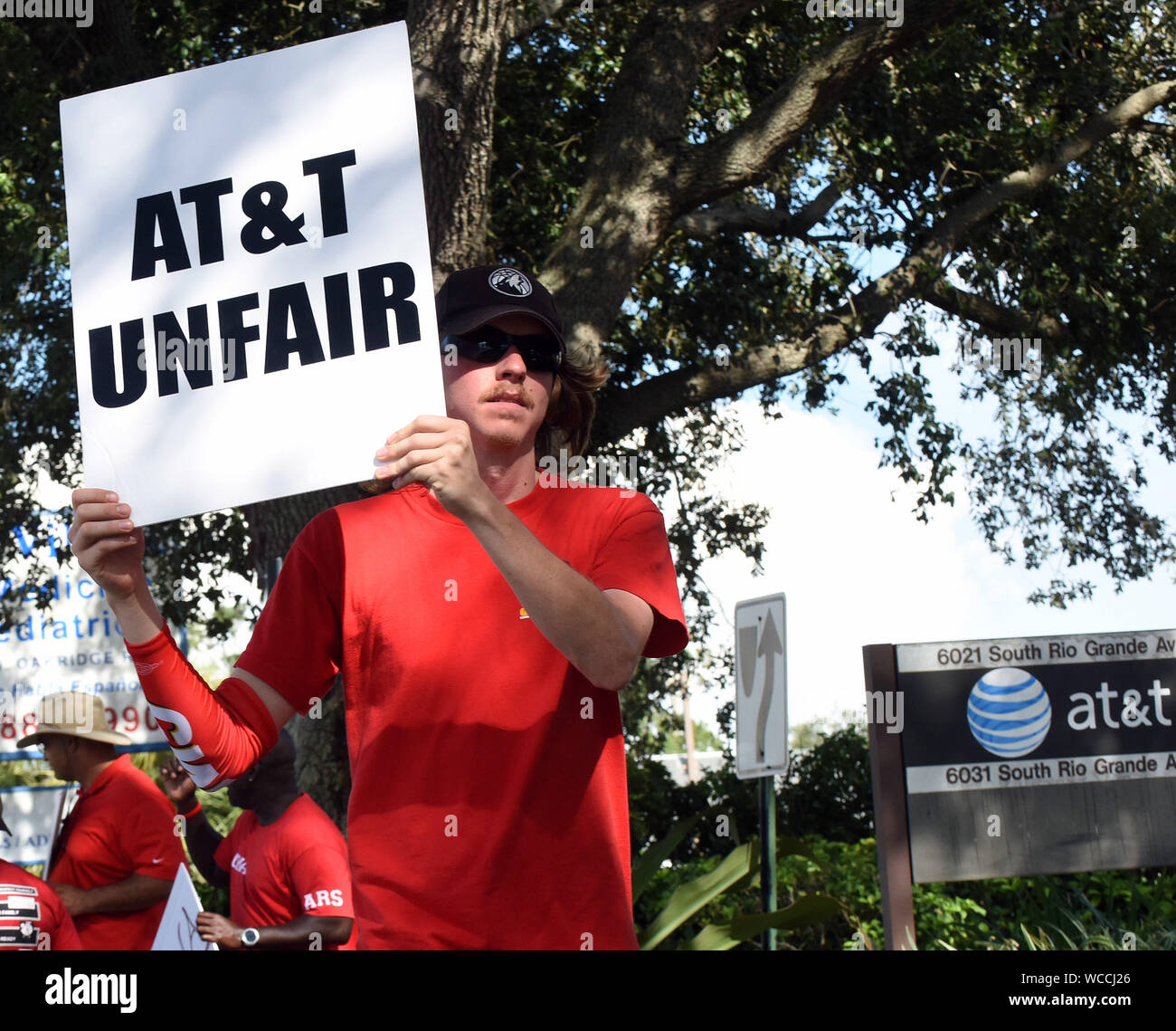 Orlando, Stati Uniti. Il 27 agosto, 2019. Elemento di raccordo detiene una targhetta nella parte anteriore di un AT&T ufficio come uno sciopero da parte dei lavoratori di comunicazione d'America entra nel suo quinto giorno in nove Stati del Sud.Oltre 20.000 CWA europea membri hanno camminato fuori dopo la carica che l'azienda di telecomunicazioni non è la contrattazione in buona fede nel corso di un nuovo contratto. Credito: SOPA Immagini limitata/Alamy Live News Foto Stock