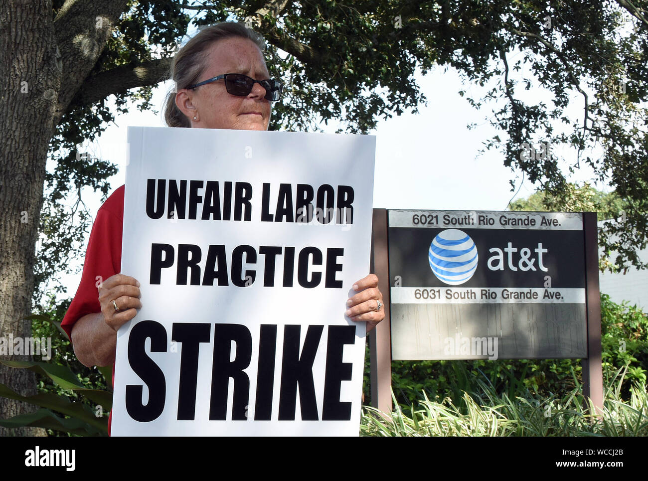 Orlando, Stati Uniti. Il 27 agosto, 2019. Elemento di raccordo detiene una targhetta nella parte anteriore di un AT&T ufficio come uno sciopero da parte dei lavoratori di comunicazione d'America entra nel suo quinto giorno in nove Stati del Sud.Oltre 20.000 CWA europea membri hanno camminato fuori dopo la carica che l'azienda di telecomunicazioni non è la contrattazione in buona fede nel corso di un nuovo contratto. Credito: SOPA Immagini limitata/Alamy Live News Foto Stock