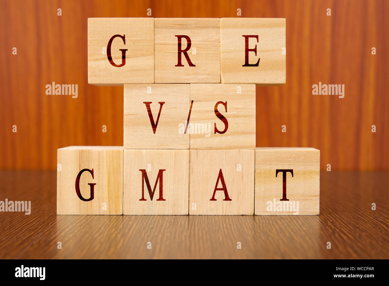 Concetto di vs GRE GMAT Exam differenze nel blocco di legno lettere sul tavolo. Foto Stock