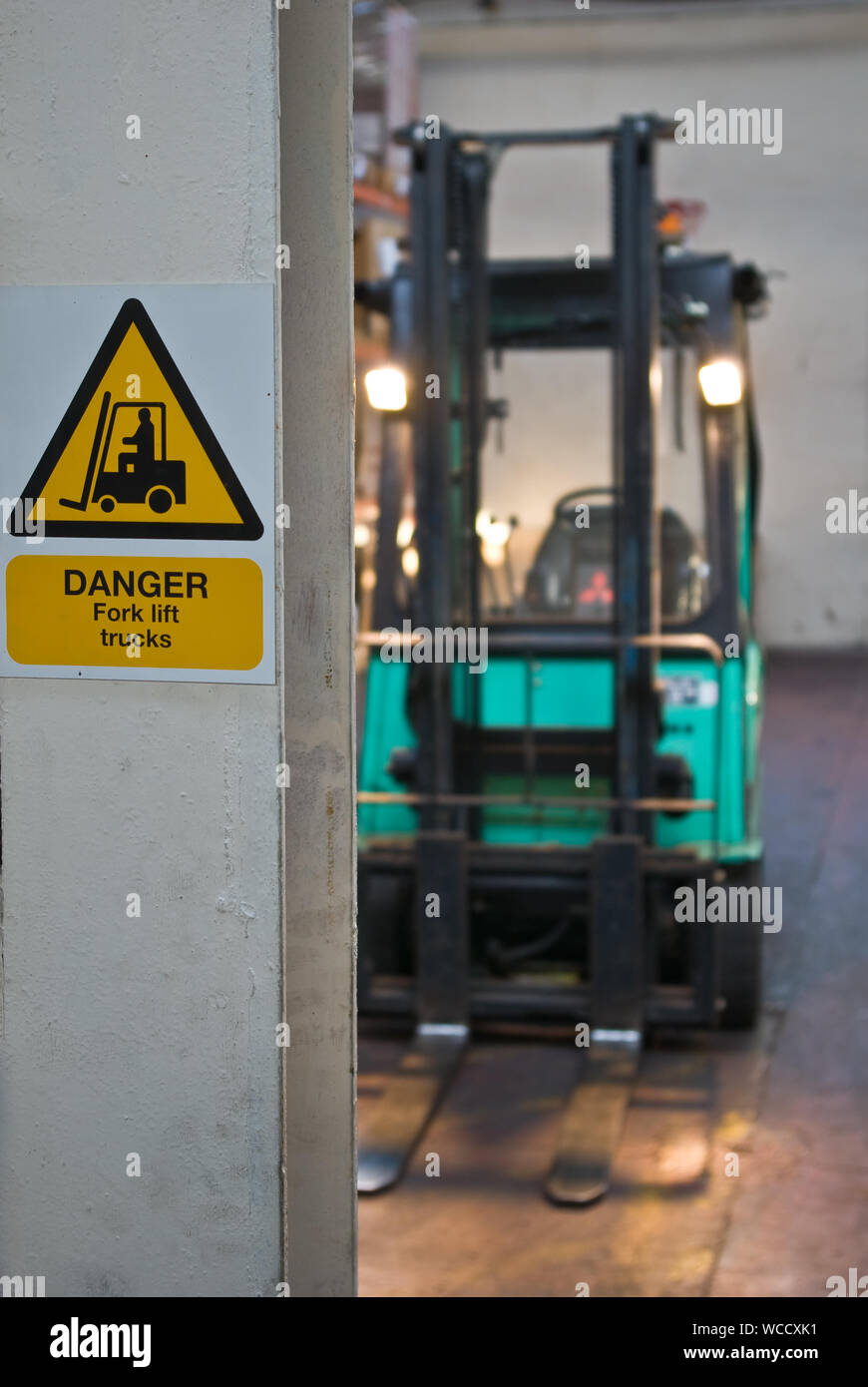 'Drabbia carrello elevatore a forca' segno su un montante con un carrello elevatore a forca a distanza Foto Stock
