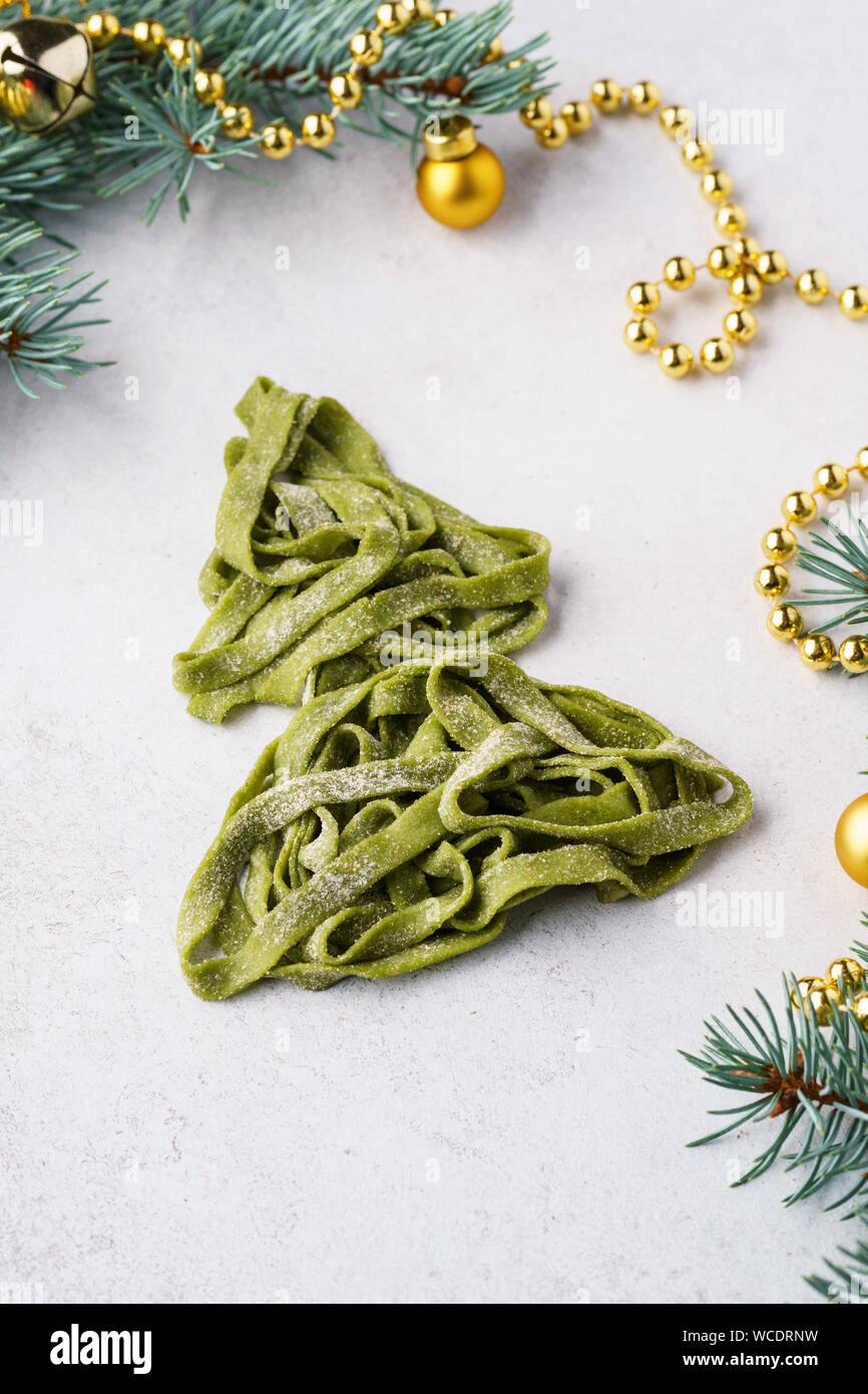 Albero di Natale fatto di freschi fatti in casa pasta di spinaci. Xmas sfondo con abete rami e decorazione. Foto Stock