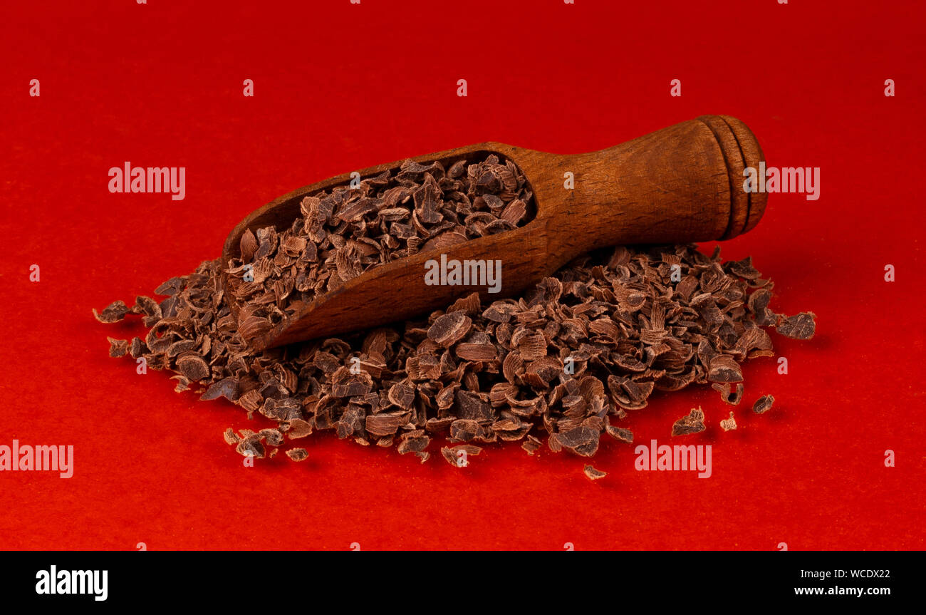 Il cioccolato grattugiato in legno isolata scoop sul rosso, colore di sfondo e primo piano Foto Stock Il cioccolato grattugiato in legno isolata scoop sul rosso, colore di sfondo e primo piano Foto Stock