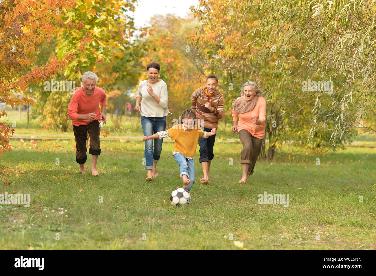 Grande famiglia felice a giocare a calcio in posizione di parcheggio Foto Stock