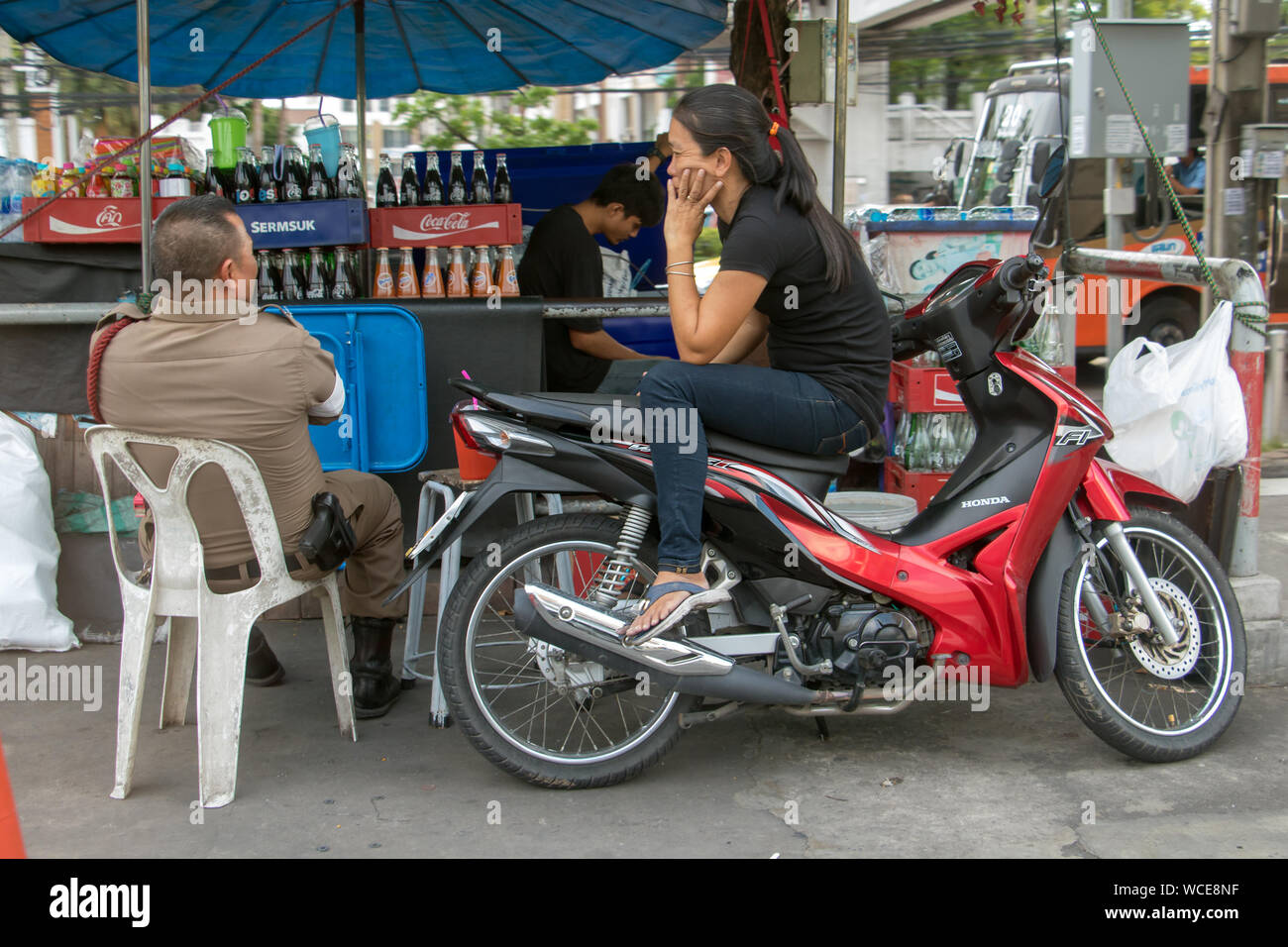 SAMUT PRAKAN, Thailandia, Giu 03 2019, un poliziotto si siede sul mercato e a parlare con una donna seduta su una motocicletta. Foto Stock