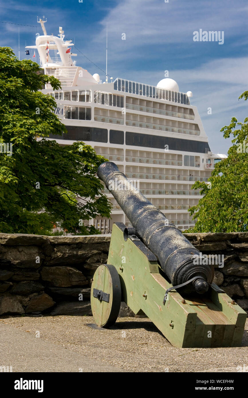 Das Kreuzfahrtschiff MSC Orchestra am Skagenkai überrragt die alten Kanonen auf dem Stavanger Valberget Foto Stock