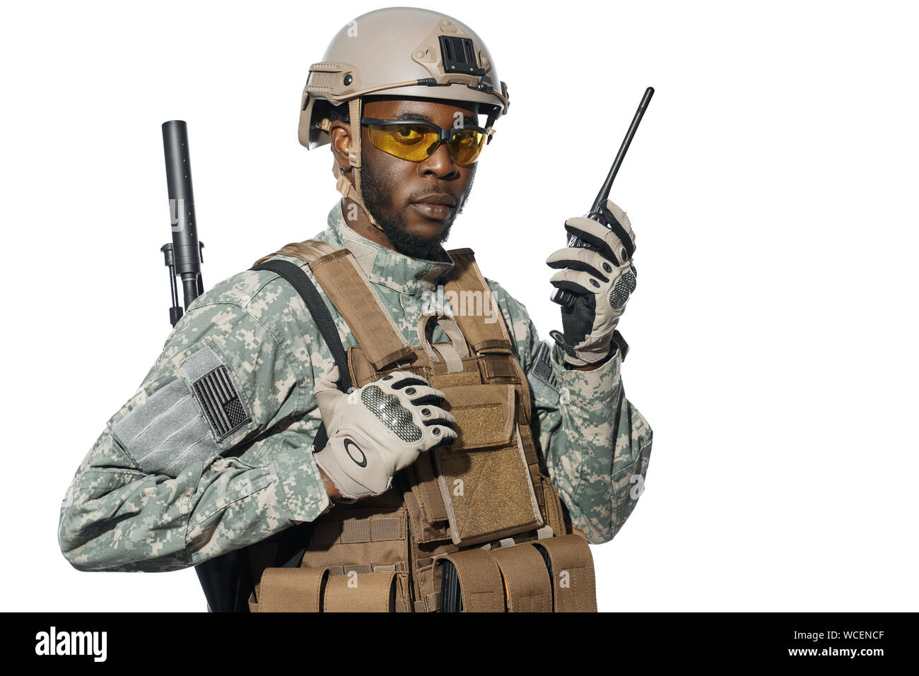 Soldato americano guardando la fotocamera utilizzando l'installazione di radio per la comunicazione a distanza. Maschio africano soldato dell'esercito che indossano uniformi e grande corazza comunicante con la sede centrale. Foto Stock