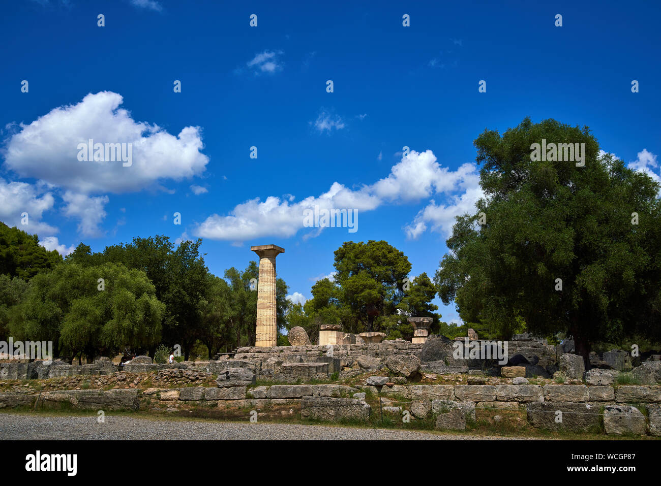 Resti del Tempio di Zeus ad Olimpia con una singola colonna ricostruita e disseminati in pezzi di colonna che circonda lo zoccolo Foto Stock