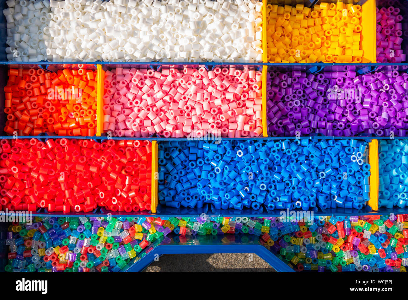 Perline di ferro ordinati per colore in cassettine in un appositamente per questo scopo in caso Foto Stock