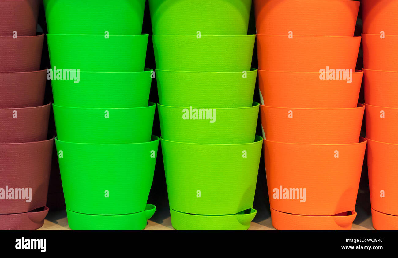 Vasi in plastica per fiori in colori luminosi. Foto Stock