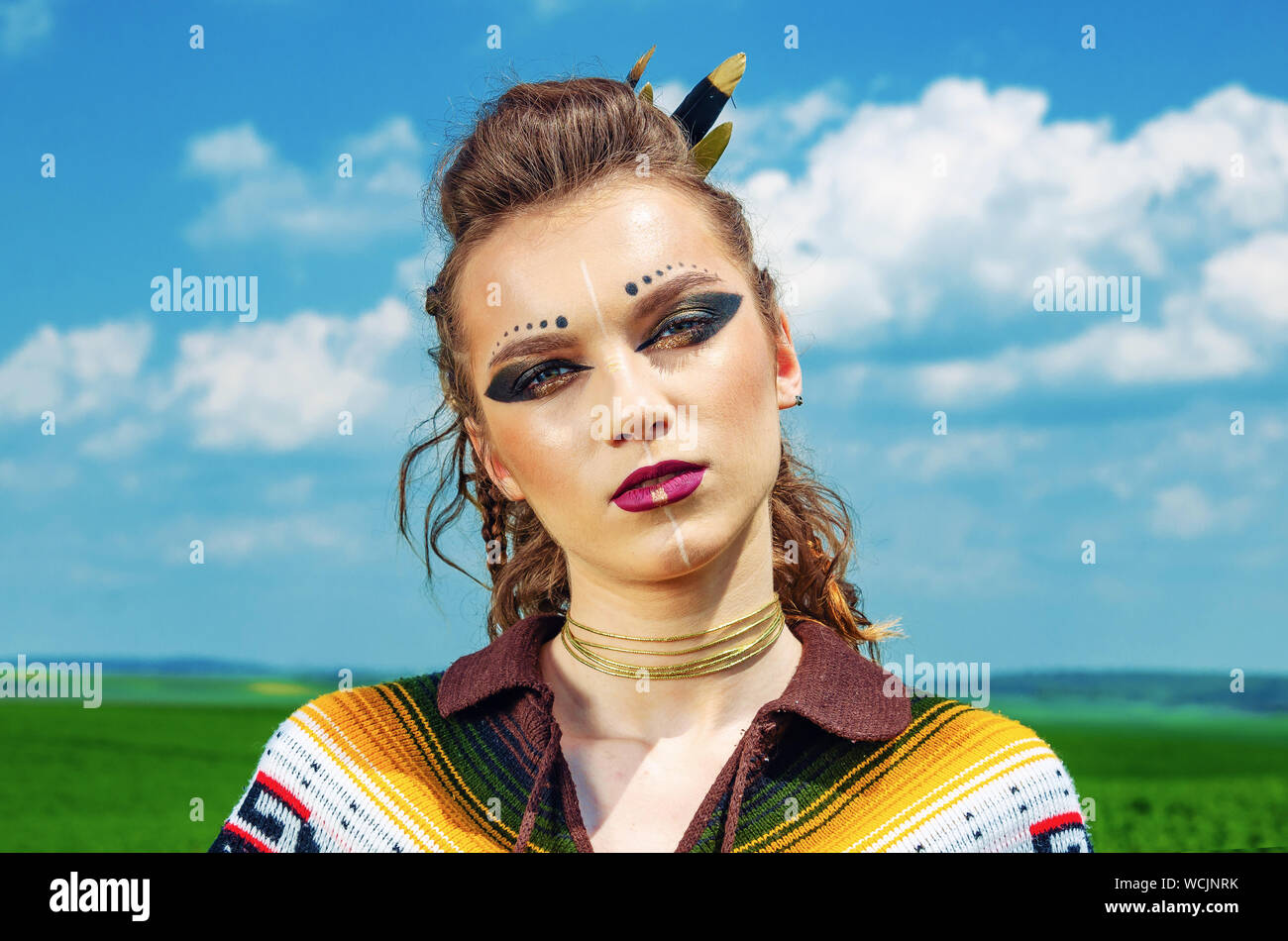 Ritratto di una ragazza con il trucco Amazon, Viking, guerra aggressiva di  vernice. Vestito in un poncho sullo sfondo del cielo Foto stock - Alamy