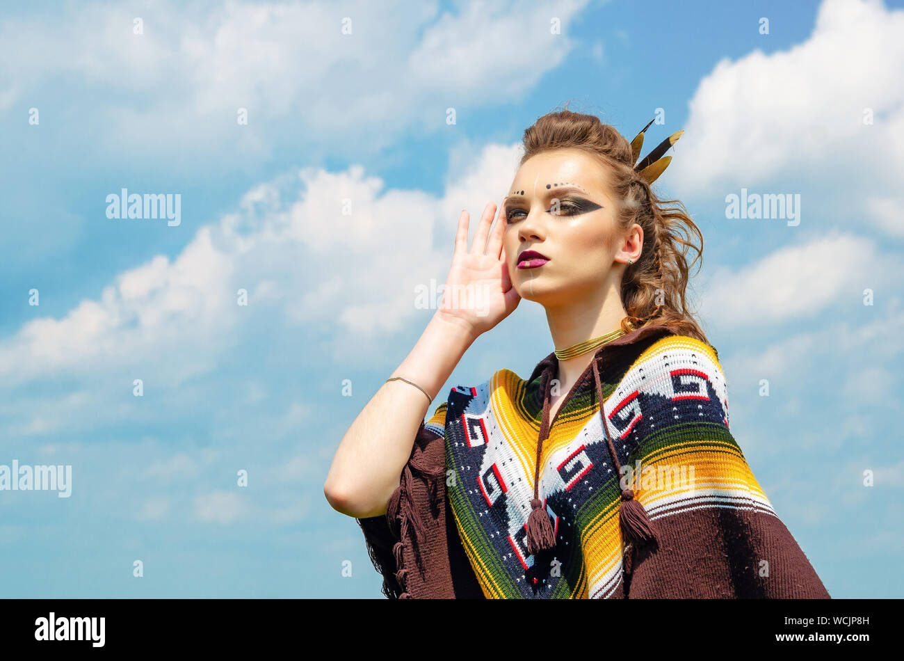 Ritratto di una ragazza con il trucco Amazon, Viking, guerra aggressiva di  vernice. Vestito in un poncho sullo sfondo del cielo Foto stock - Alamy