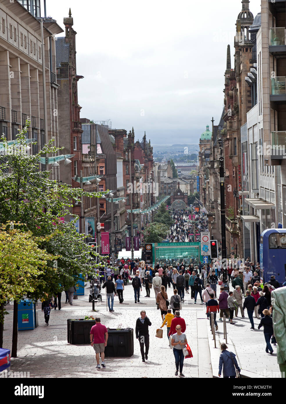 Buchanan Street Glasgow, Scotland, Regno Unito. 28 Agosto, 2019. Gli amanti dello shopping e visitatori di passeggiare lungo la tenue luce del sole attraverso il pedestriansed Buchanan Street nel centro della città di Glasgow. La Donald Dewar statua si erge con orgoglio in cima alla strada, inaugurale del Primo ministro di Scozia e di un avvocato di devoluzione scozzese, uno sarebbe da chiedersi che cosa il suo pensiero sarebbe per quanto riguarda oggi le ultime notizie che il Primo Ministro britannico Boris Johnson ha chiesto alla regina di sospendere il parlamento del Regno Unito a partire dalla metà di settembre. Foto Stock