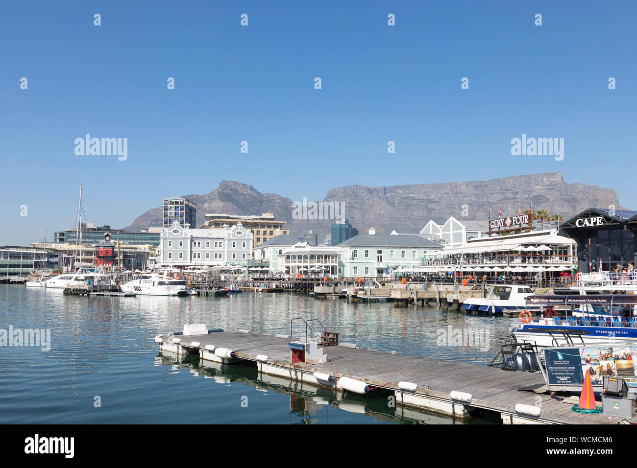 Cape Town Harbour e il V e A Waterfront con ristoranti, negozi e una vista di Devils Peak e la Montagna della Tavola su una soleggiata giornata invernale Foto Stock