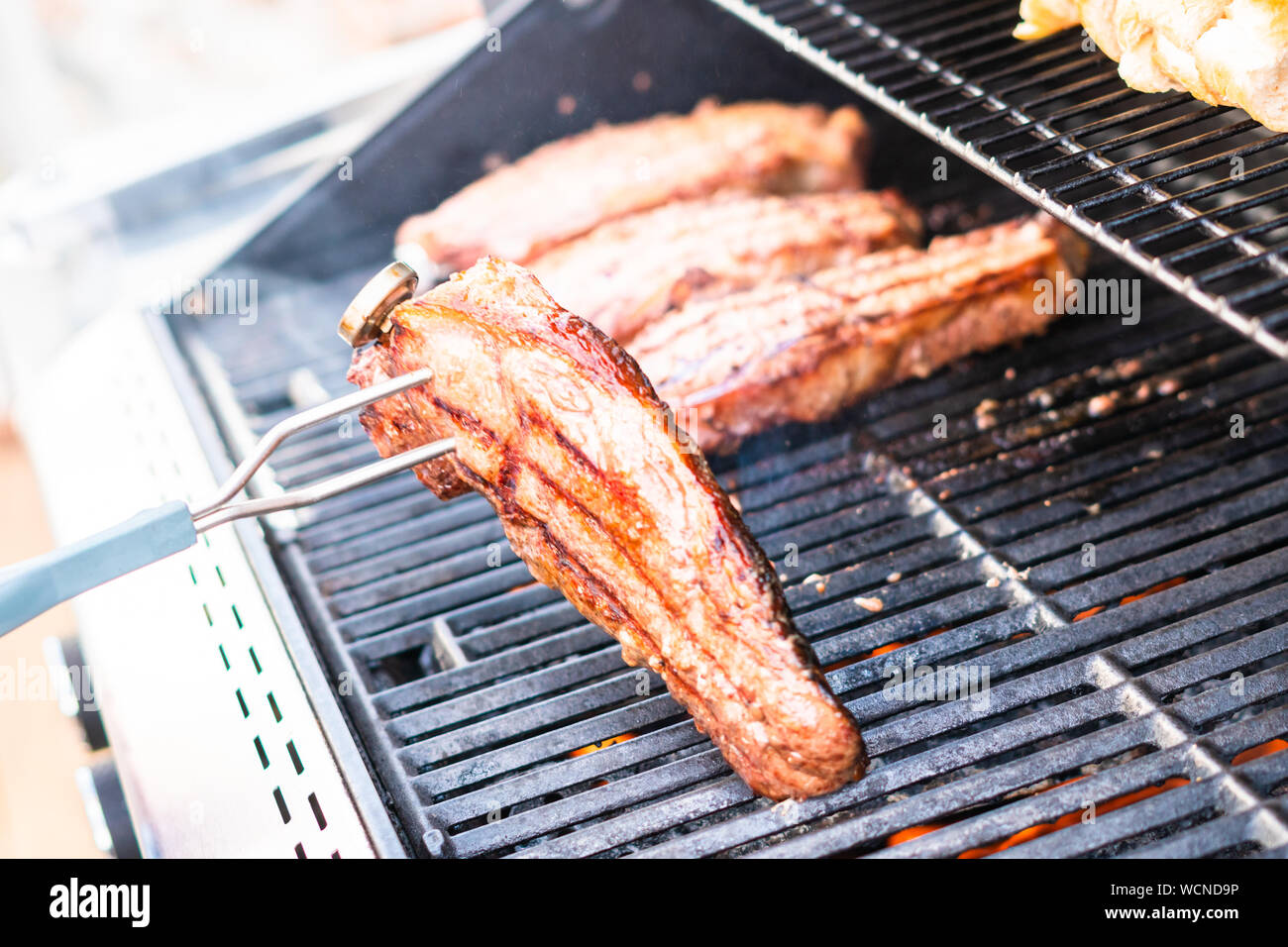La grigliatura New York strip steak su outdoor grill a gas. Foto Stock
