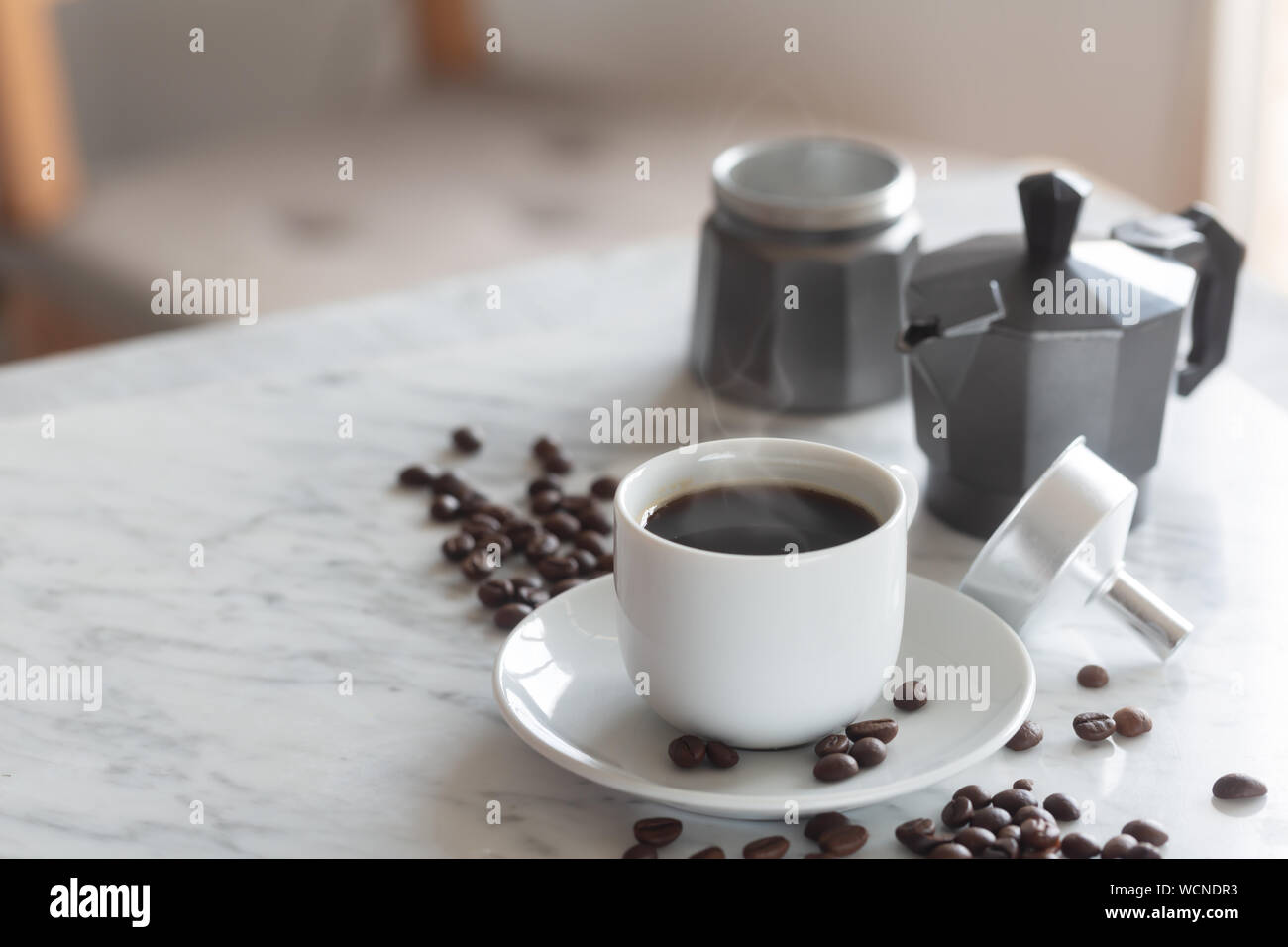 Calda tazza di espresso o caffè americano in un tradizionale bicchiere  bianco su un tavolo Foto stock - Alamy