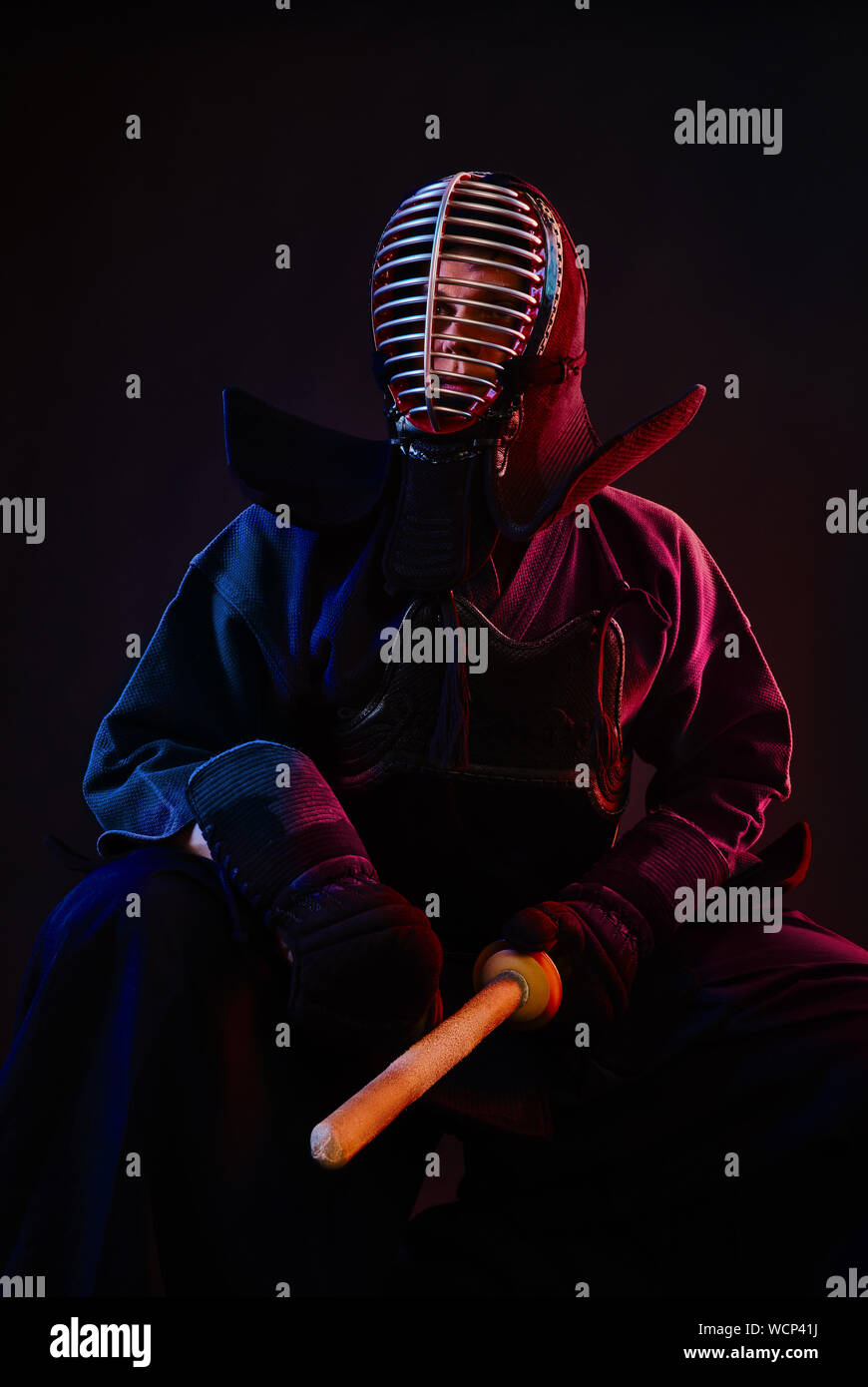 Close up. Combattente di Kendo di indossare in una corazza, tradizionale  kimono, casco, seduto, praticanti di arti marziali con shinai spada di  bambù, sfondo nero Foto stock - Alamy