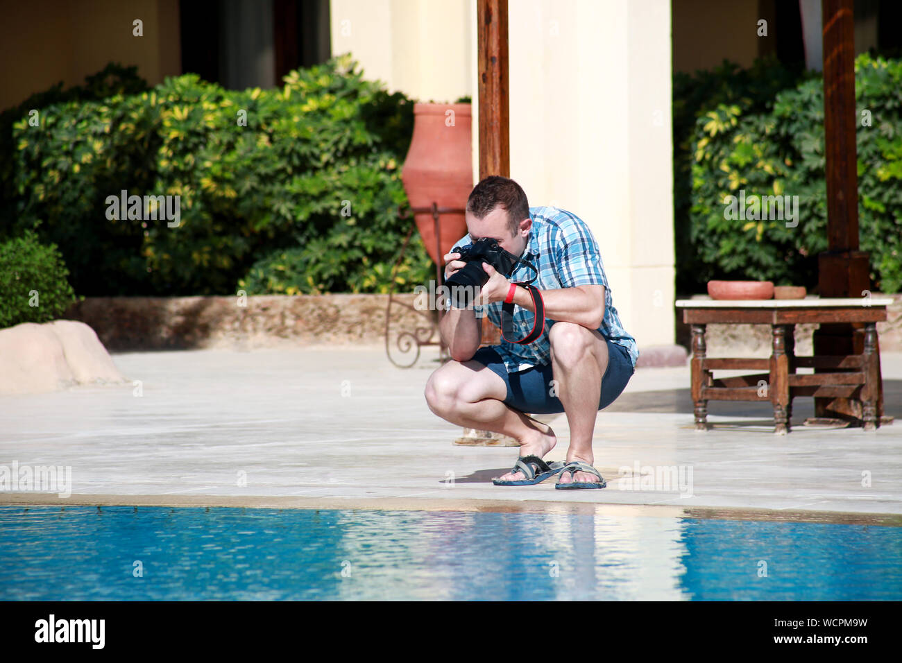 Fotografo professionista, turistico e traveler sulla piscina del resort, egli è di scattare la foto, rendendo la fotografia di acqua e l'ambiente. Foto Stock