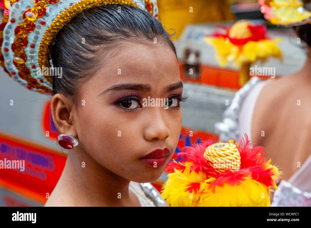 Un elementare Schoolgirl attende per eseguire nell'Tambor Trumpa Martsa Musika (Drum & Bugle) Concorso, Dinagyang Festival, Iloilo City, Filippine. Foto Stock
