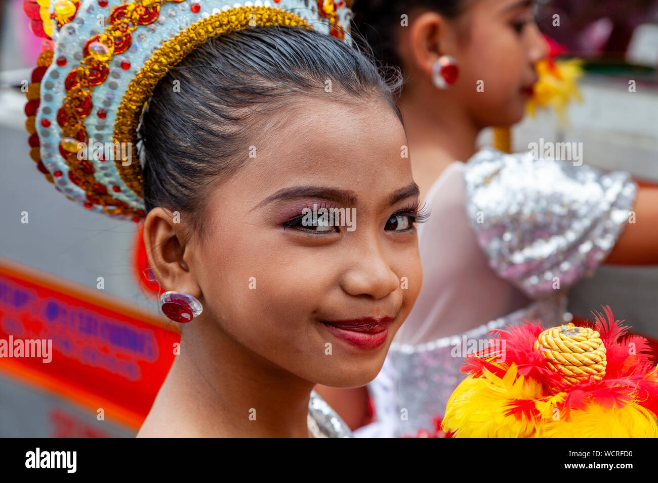 Un elementare Schoolgirl attende per eseguire nell'Tambor Trumpa Martsa Musika (Drum & Bugle) Concorso, Dinagyang Festival, Iloilo City, Filippine. Foto Stock