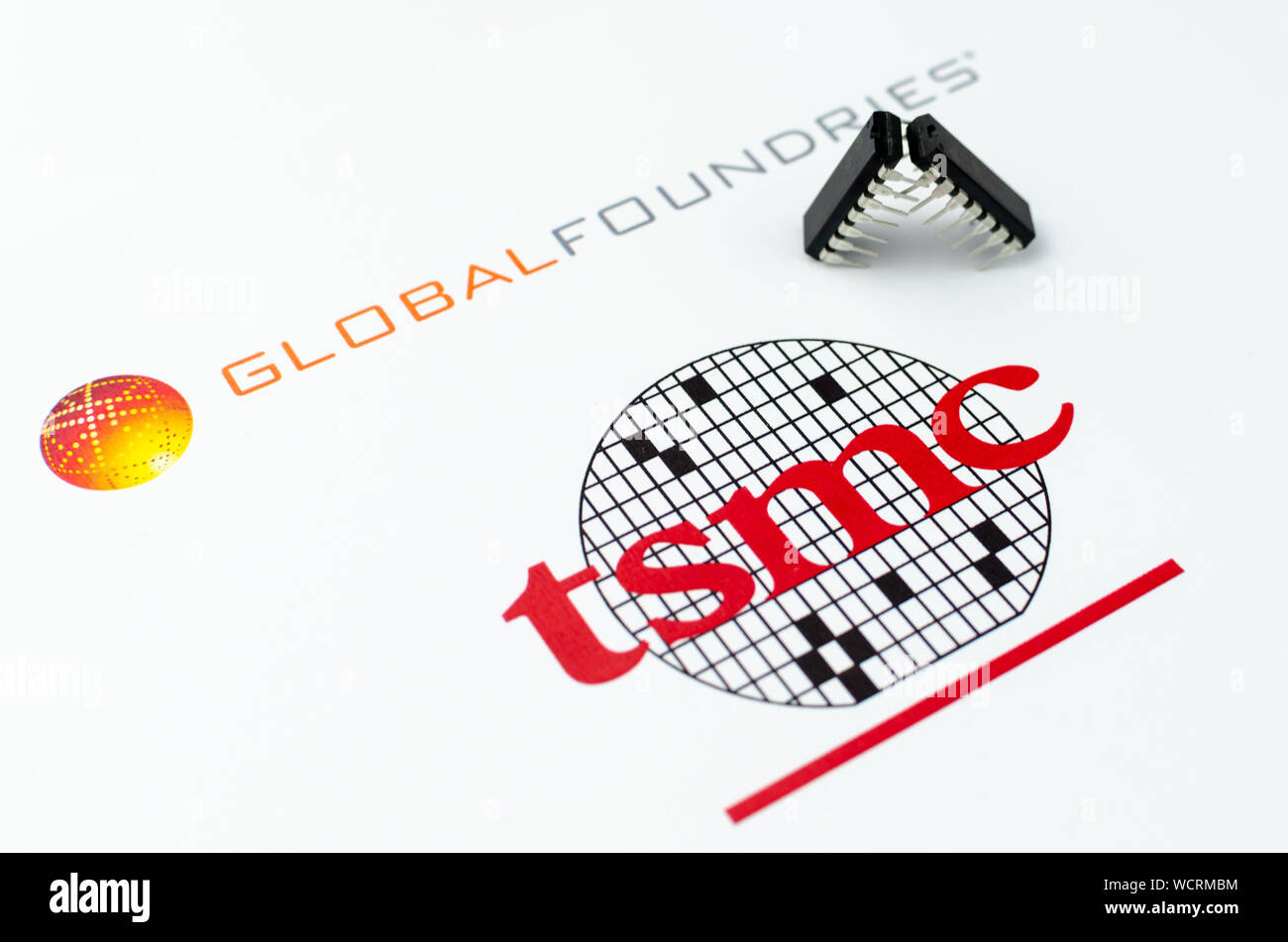 GLOBAL FONDERIE TSMC con logo stampato sulla carta e microchip un 'lotta' posizione. Foto concettuale illustra la battaglia legale tra la Foto Stock