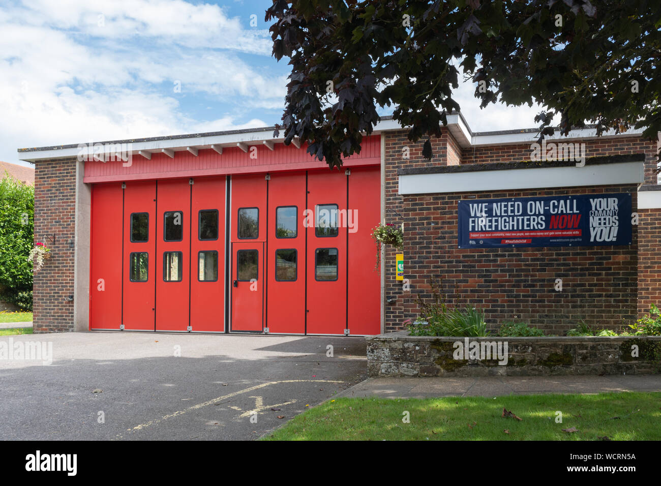 Stazione dei vigili del fuoco con il reclutamento di firmare o banner per chiamare i vigili del fuoco, la vostra comunità ha bisogno di voi, Petworth, West Sussex, Regno Unito Foto Stock