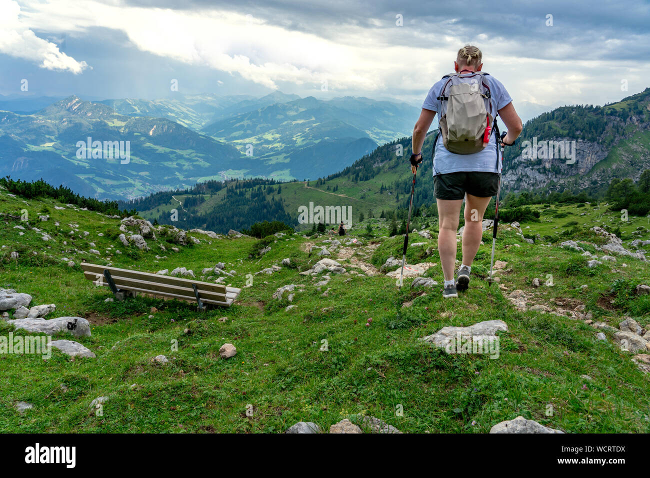 Donna turistiche escursioni in Alto Adige alpi con bastoni da passeggio poli dal retro Foto Stock