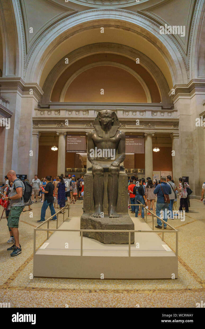 Si tratta di una monumentale egiziana antica statua di un faraone seduto presso la hall del Metropolitan Museum of Art (TEM). Il più grande museo d'arte. Foto Stock