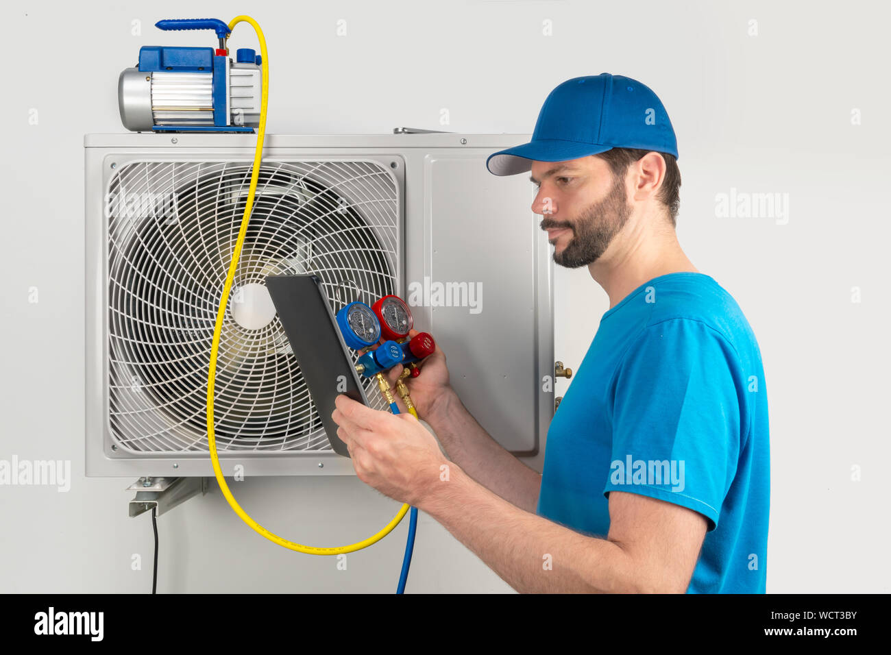 Servizio di installazione di fissare la riparazione manutenzione di un condizionatore di aria unità esterna, da cryogenist tecnico lavoratore evacuare il sistema con pompa per vuoto a Foto Stock