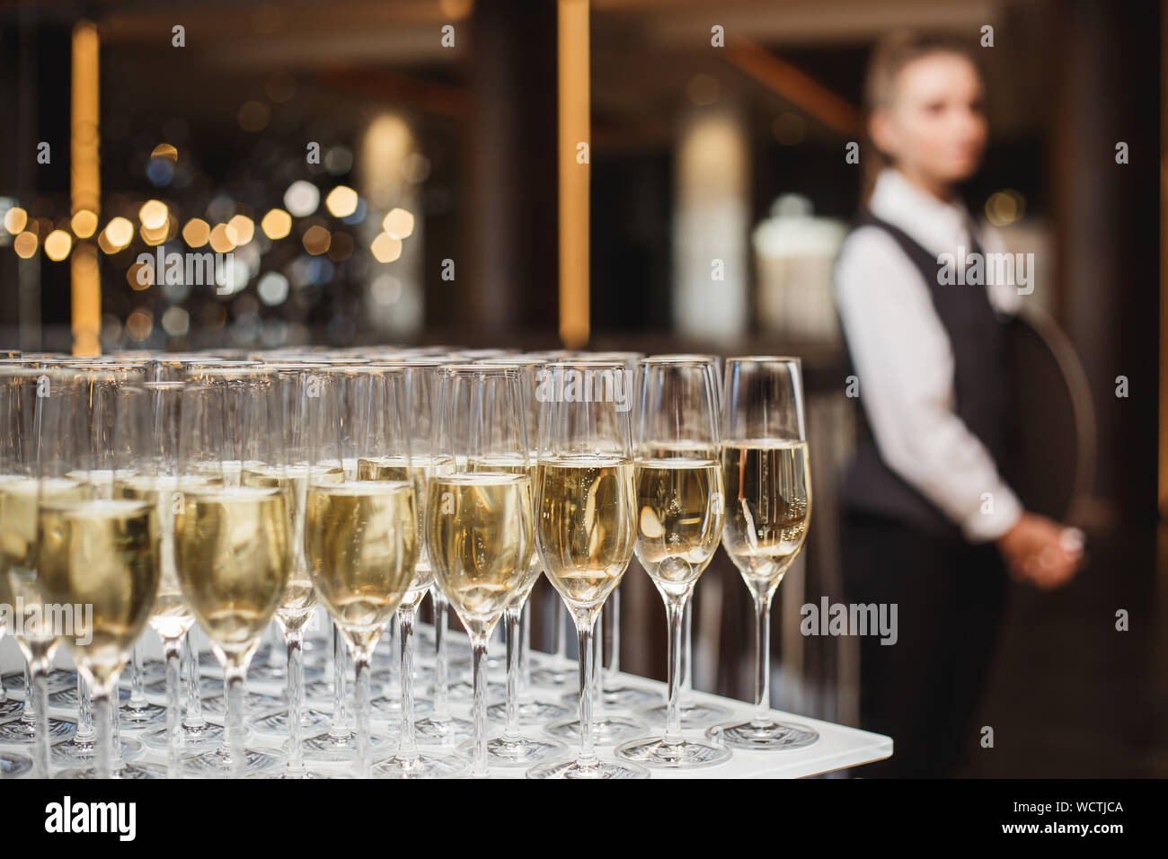 Occhiali con champagne al buffet e cameriere in background. Foto Stock