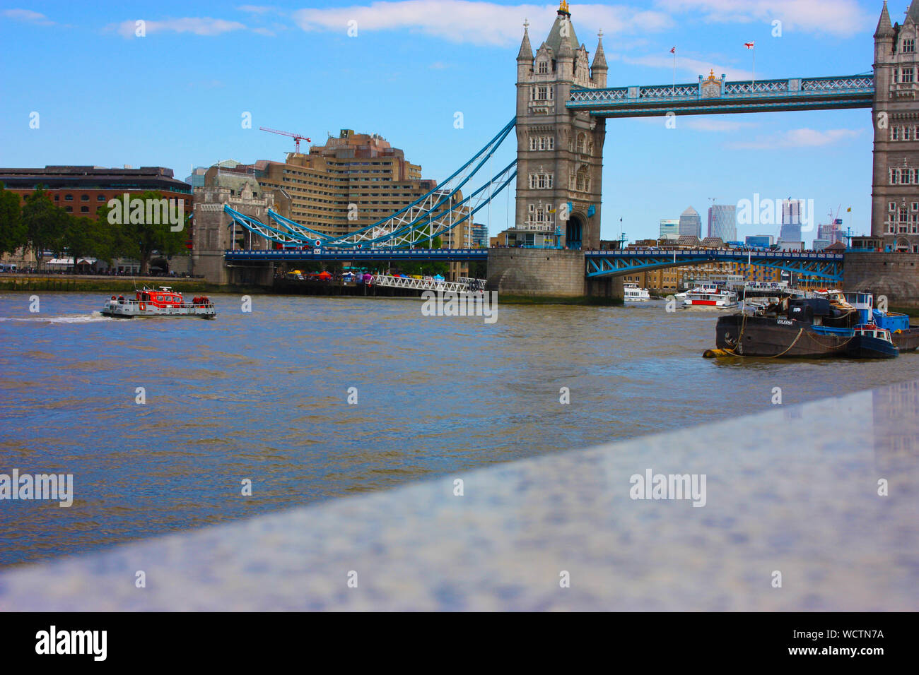 Il famoso Ponte di Londra su un cielo blu giorno d'estate. Le tranquille acque del fiume Tamigi nel Regno Unito Foto Stock