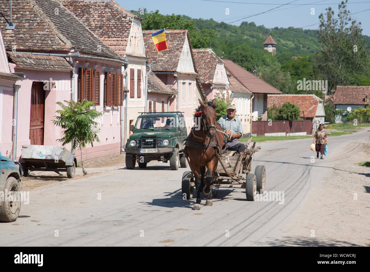 Cavallo e carrello azionato da un uomo anziano in movimento lungo la via principale del villaggio Malancrav, Transilvania, Romania Foto Stock