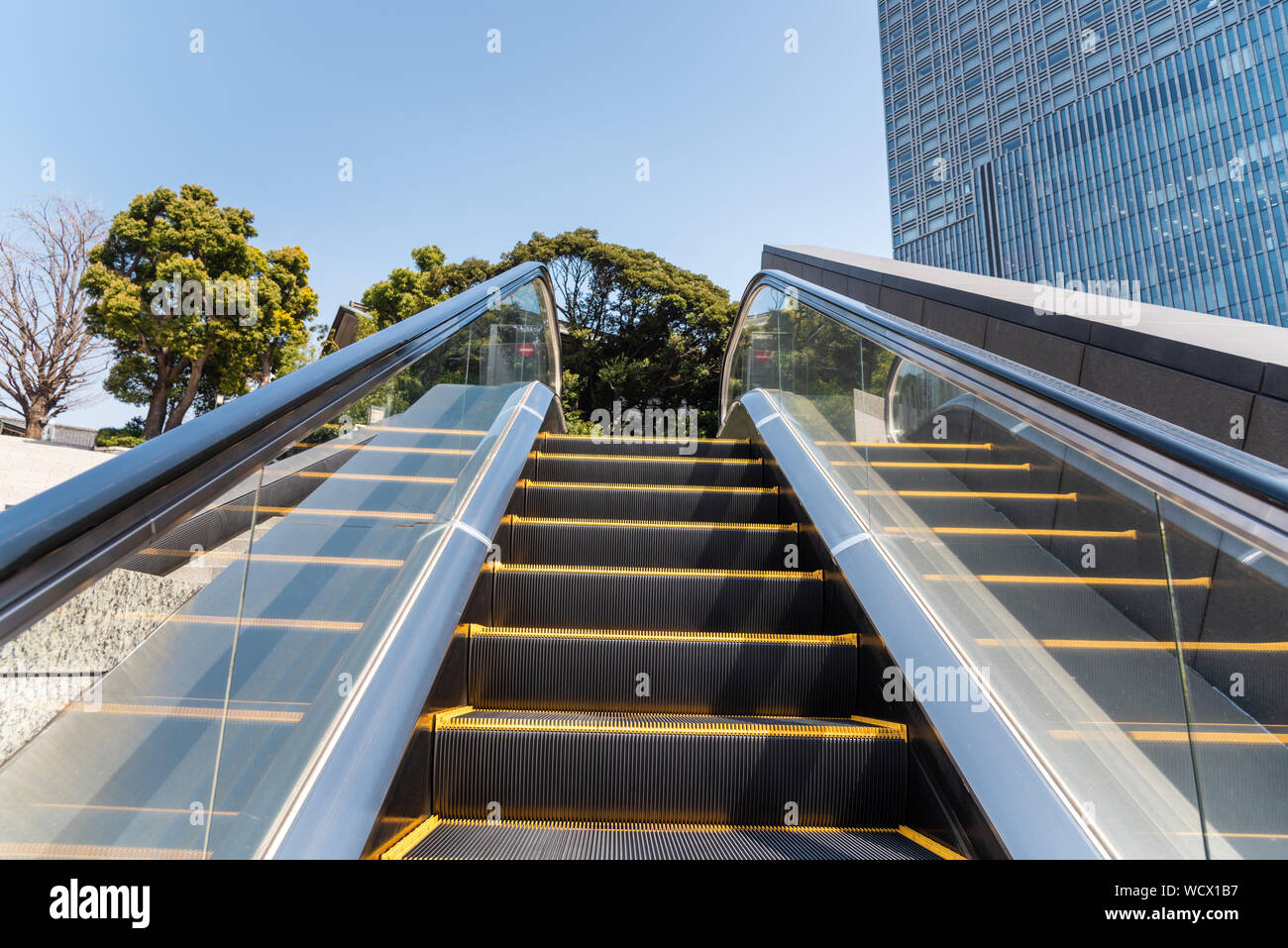 Deserta escalator per esterni in un quartiere d' affari su una soleggiata giornata invernale Foto Stock