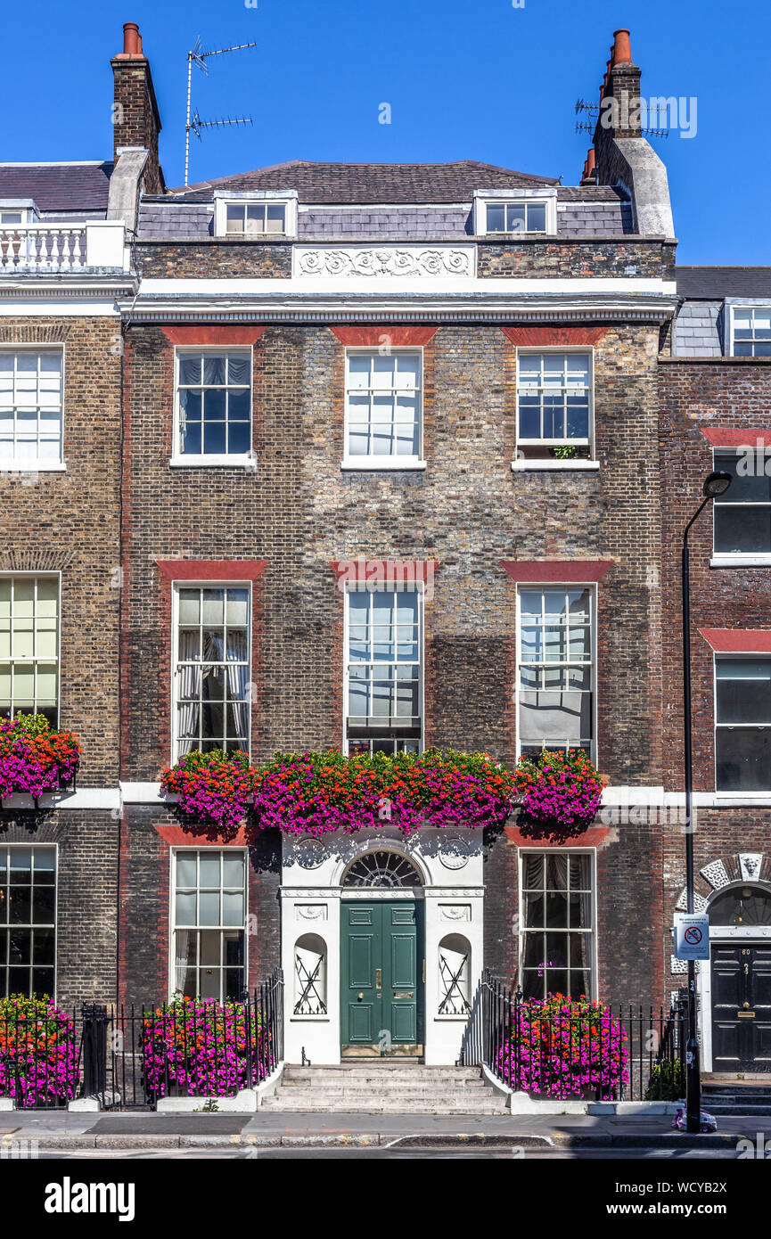 Un Georgiani terrazzati casa decorata con fiori naturali, Gower Street, Bloomsbury, Londra WC1, Inghilterra, Regno Unito. Foto Stock