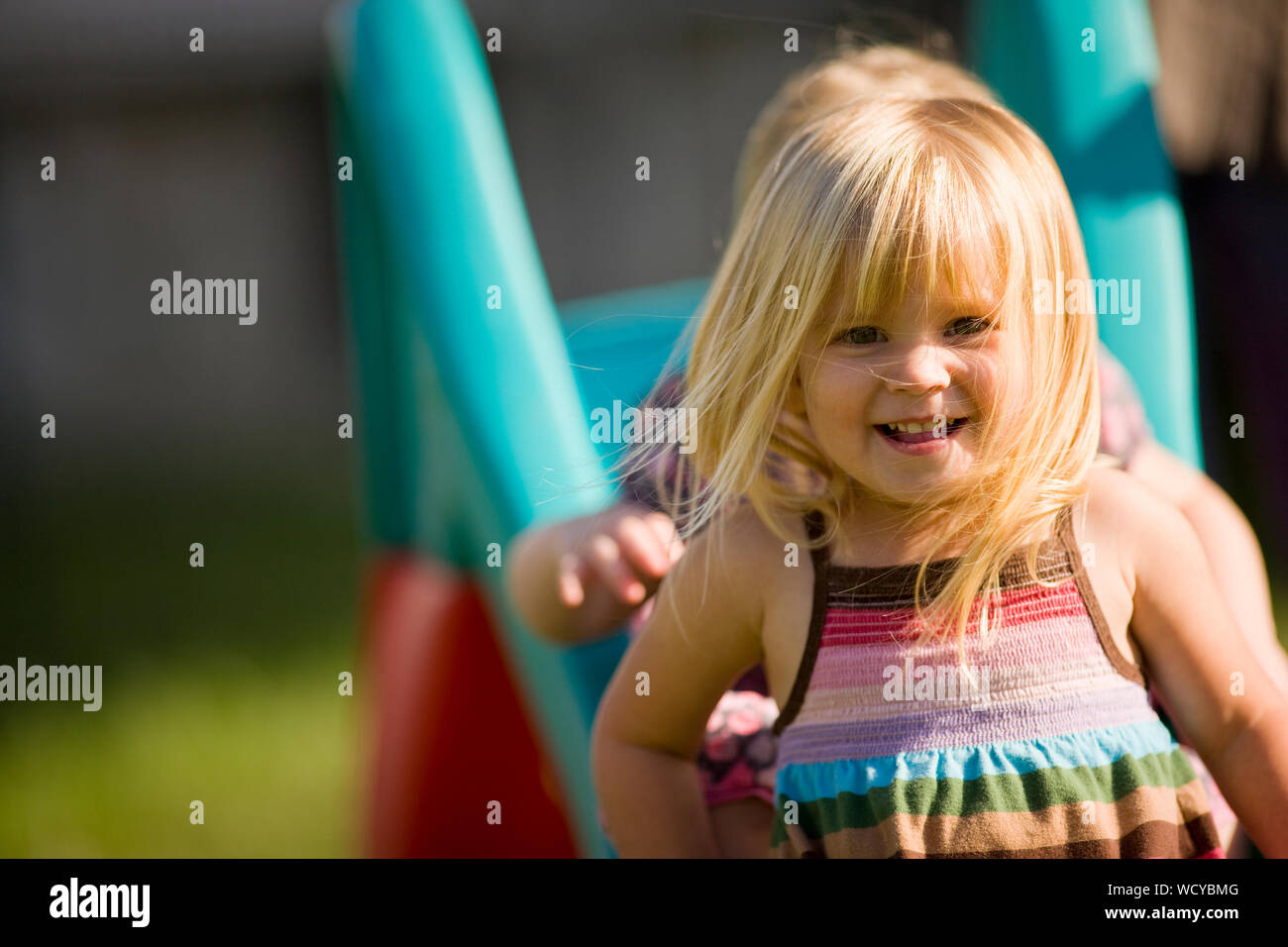 Bambina scivolare giù scorrere con la sorella del bambino Foto Stock