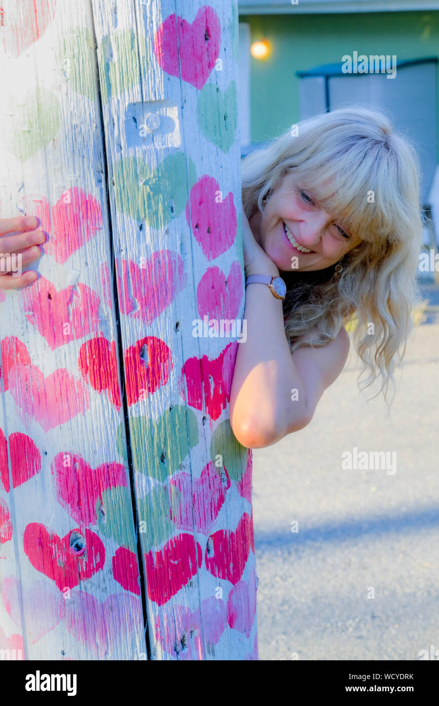 Donna felice e il cuore di legno coperto idro, telefono, polo, Foto Stock