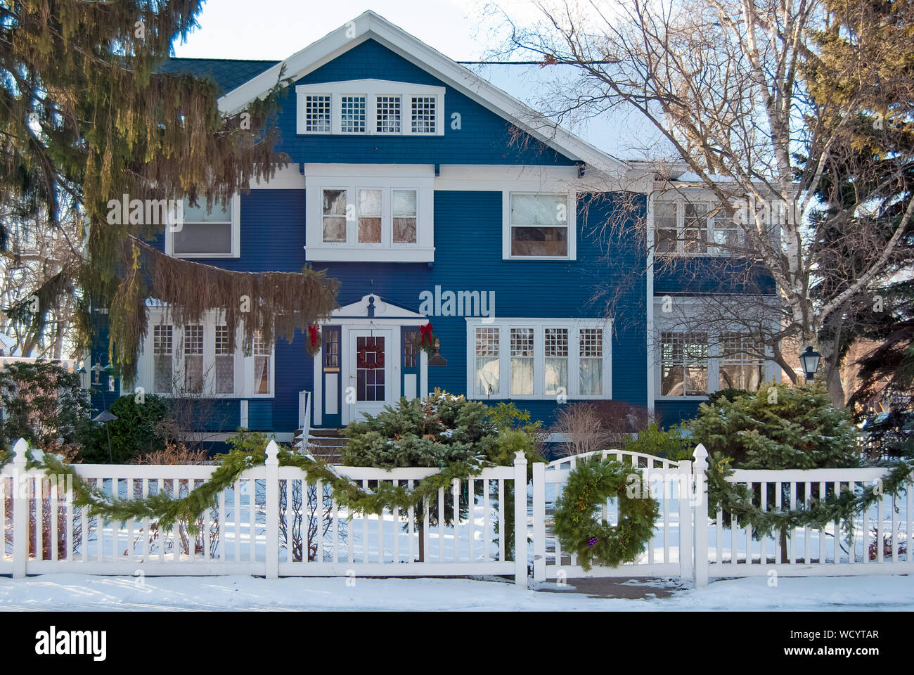 Blue House con ghirlanda di Natale sul cancello di recinzione in inverno Foto Stock