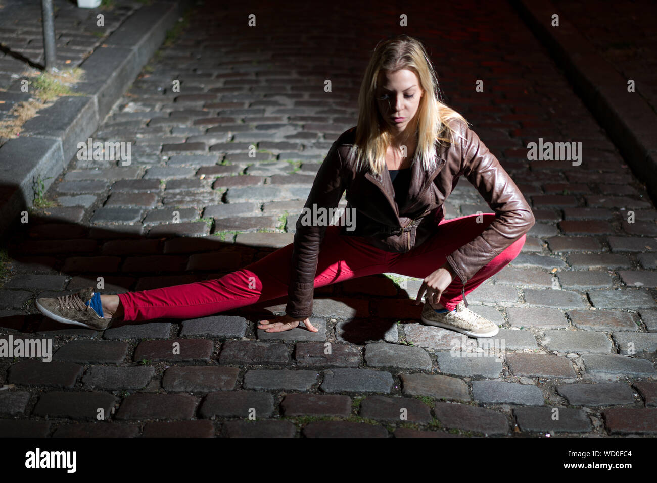 Parigi, Francia - luglio 2, 2017: giovane donna bionda sta facendo ginnastica in notturna su strada nel centro della città di Parigi Foto Stock