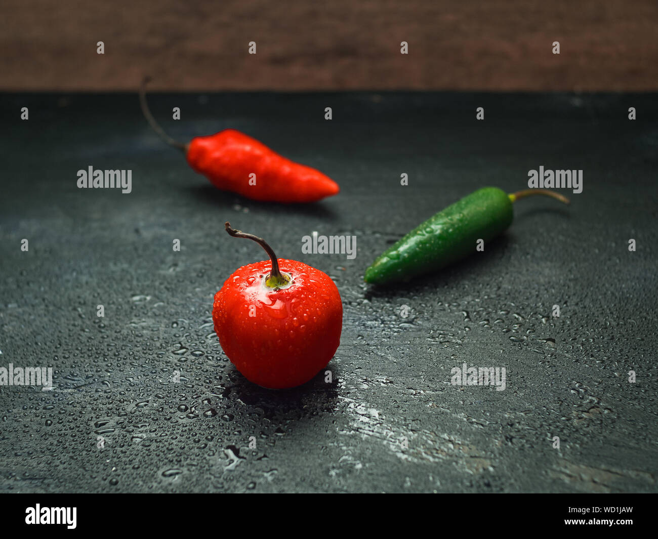 Rosso e peperoncini verdi su sfondo nero Foto Stock