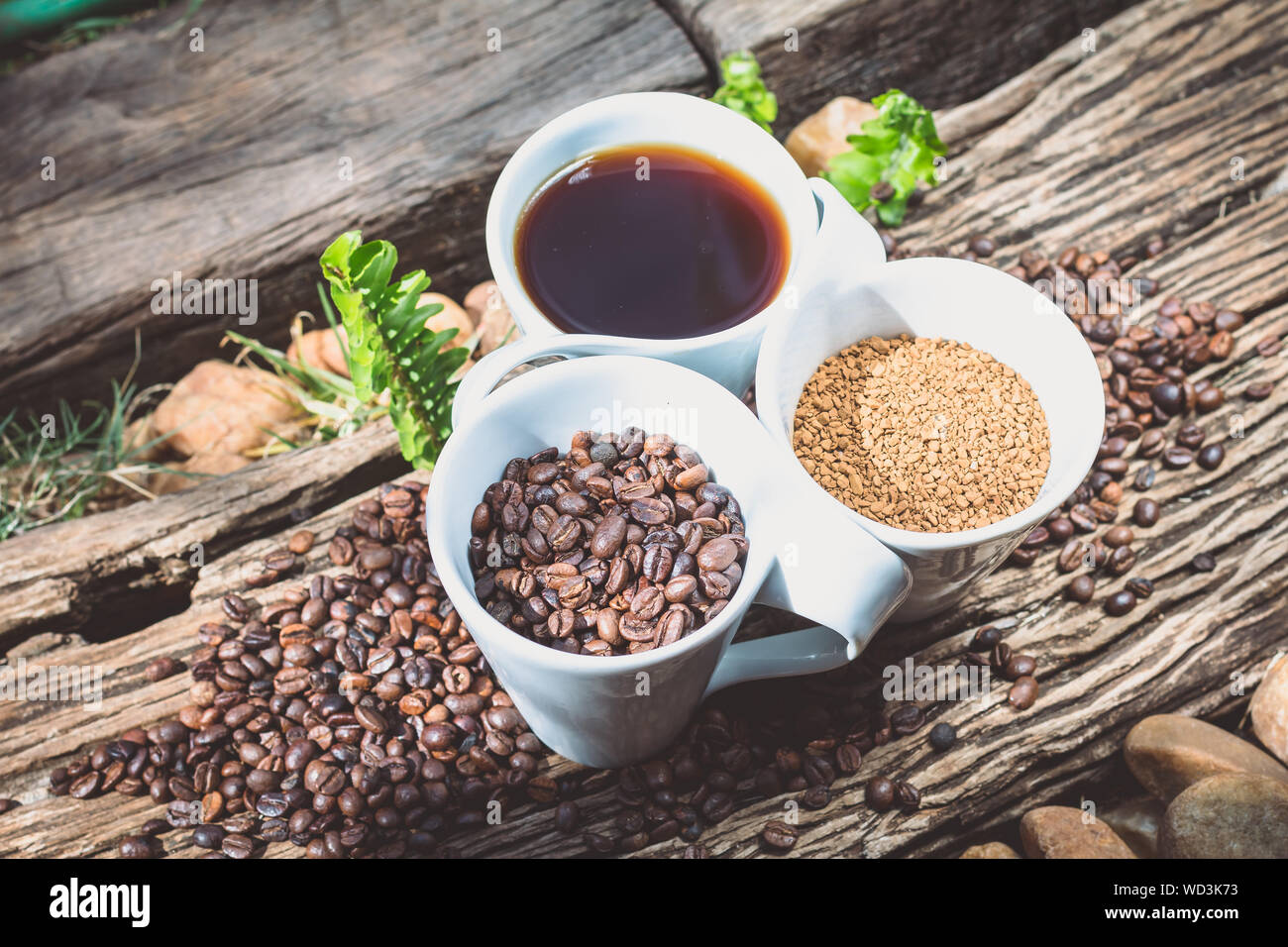 Close-up della tazza di caffè con fagioli arrosto e caffeina in tazze su legno Foto Stock