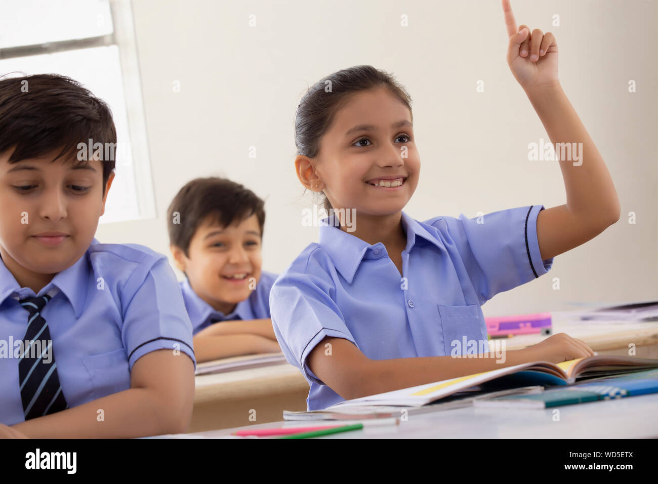 School girl per chiedere un dubbio nella classe Foto Stock