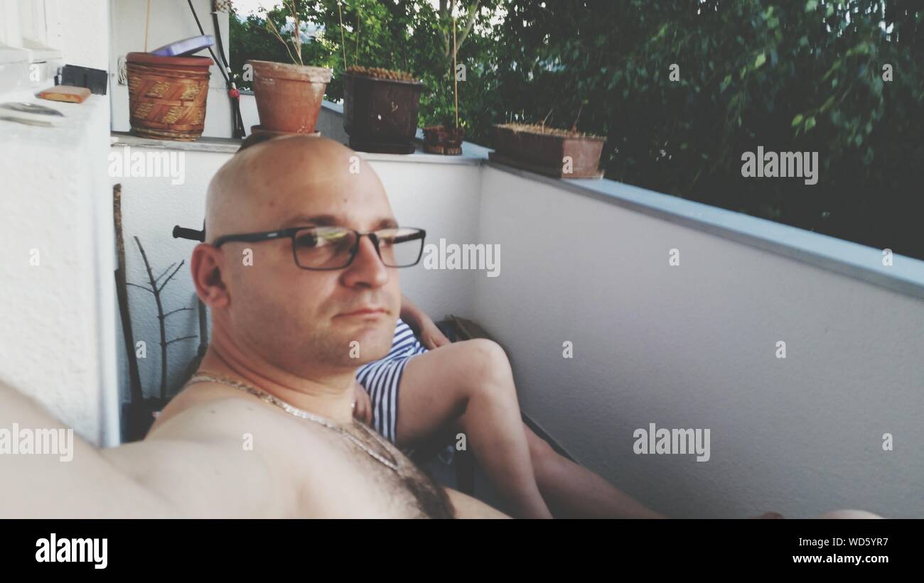 Metà uomo adulto seduti in balcone Foto Stock