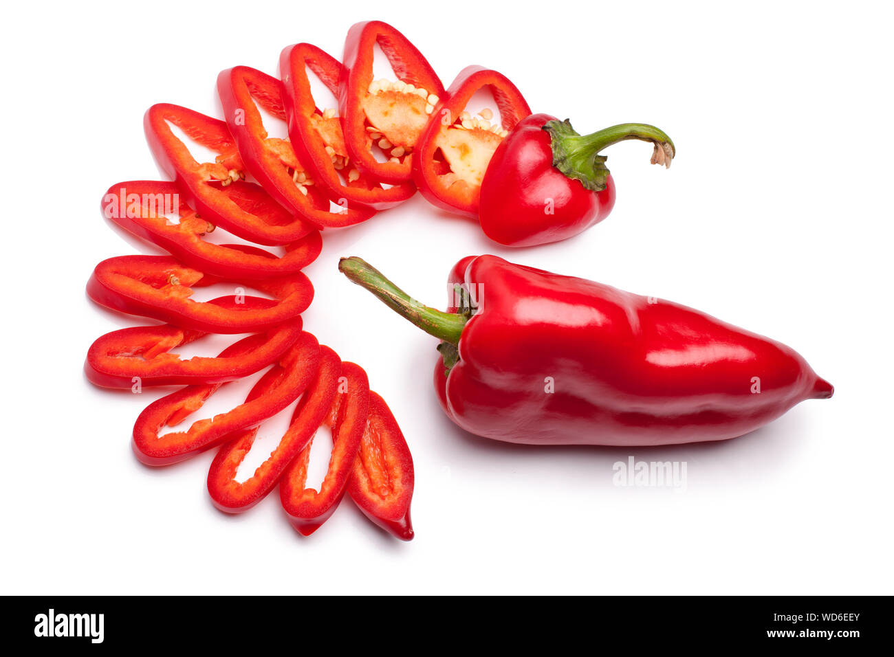 Peperone rosso tutto pepe e affettato in anelli su uno sfondo bianco isolato da vicino Foto Stock