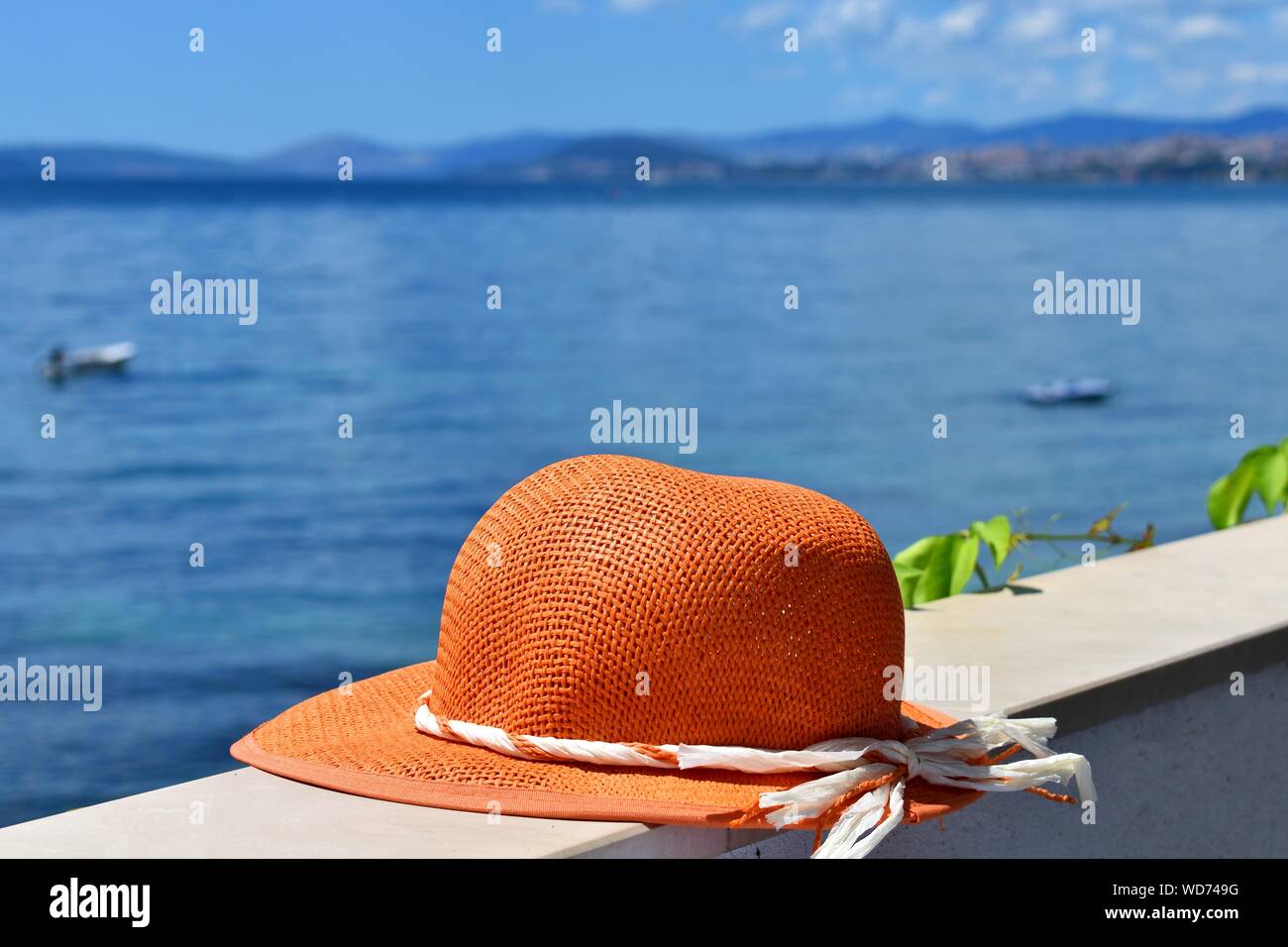 Donna cappello d'estate in terrazza con splendida vista sul mare al giorno d'estate e di sole/ immagine concettuale delle vacanze estive Foto Stock