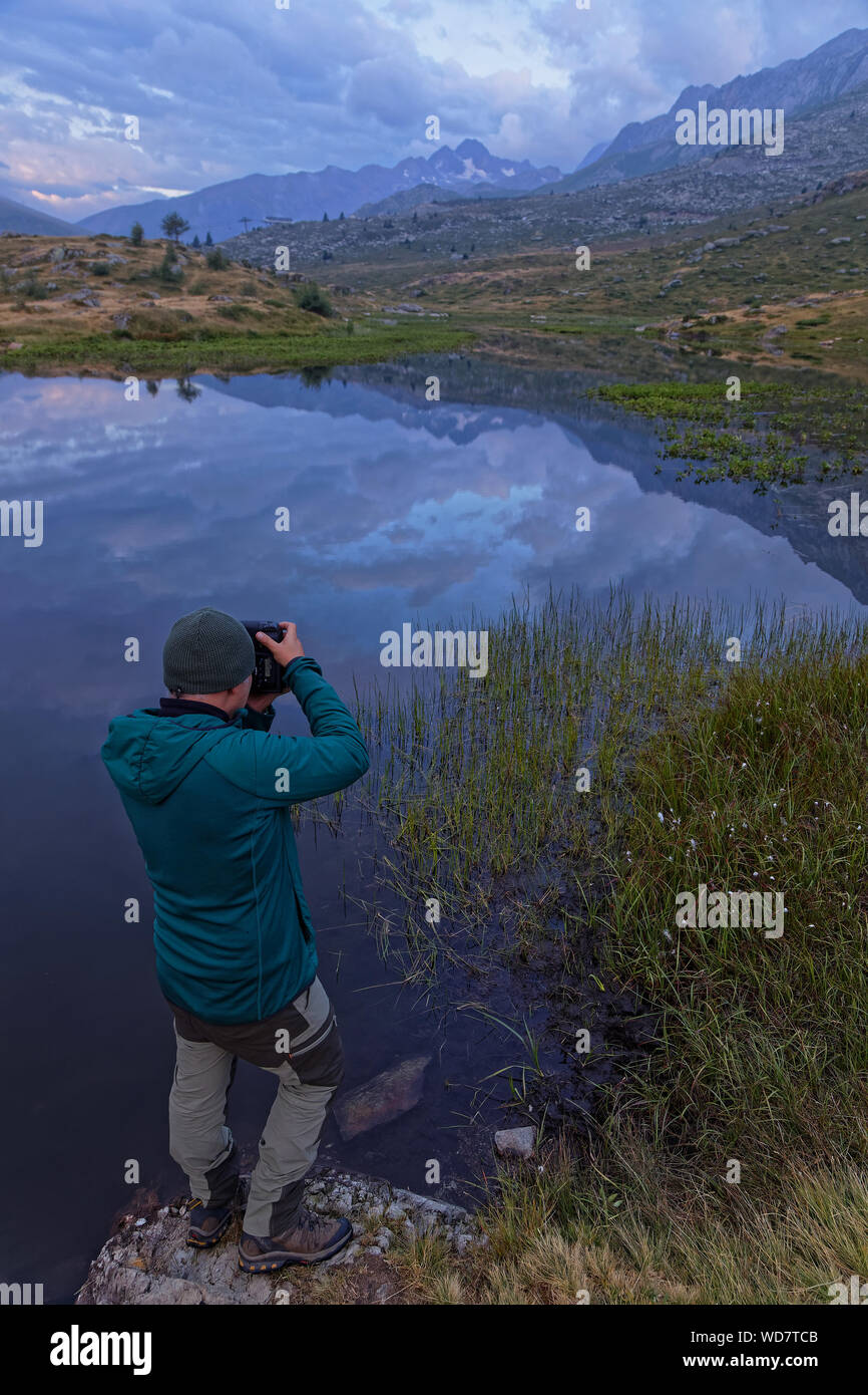 SAINT-SORLIN, Francia, 10 agosto 2019 : Fotografo spara un paesaggio di un lago di montagna nelle prime luci dell'alba. Foto Stock