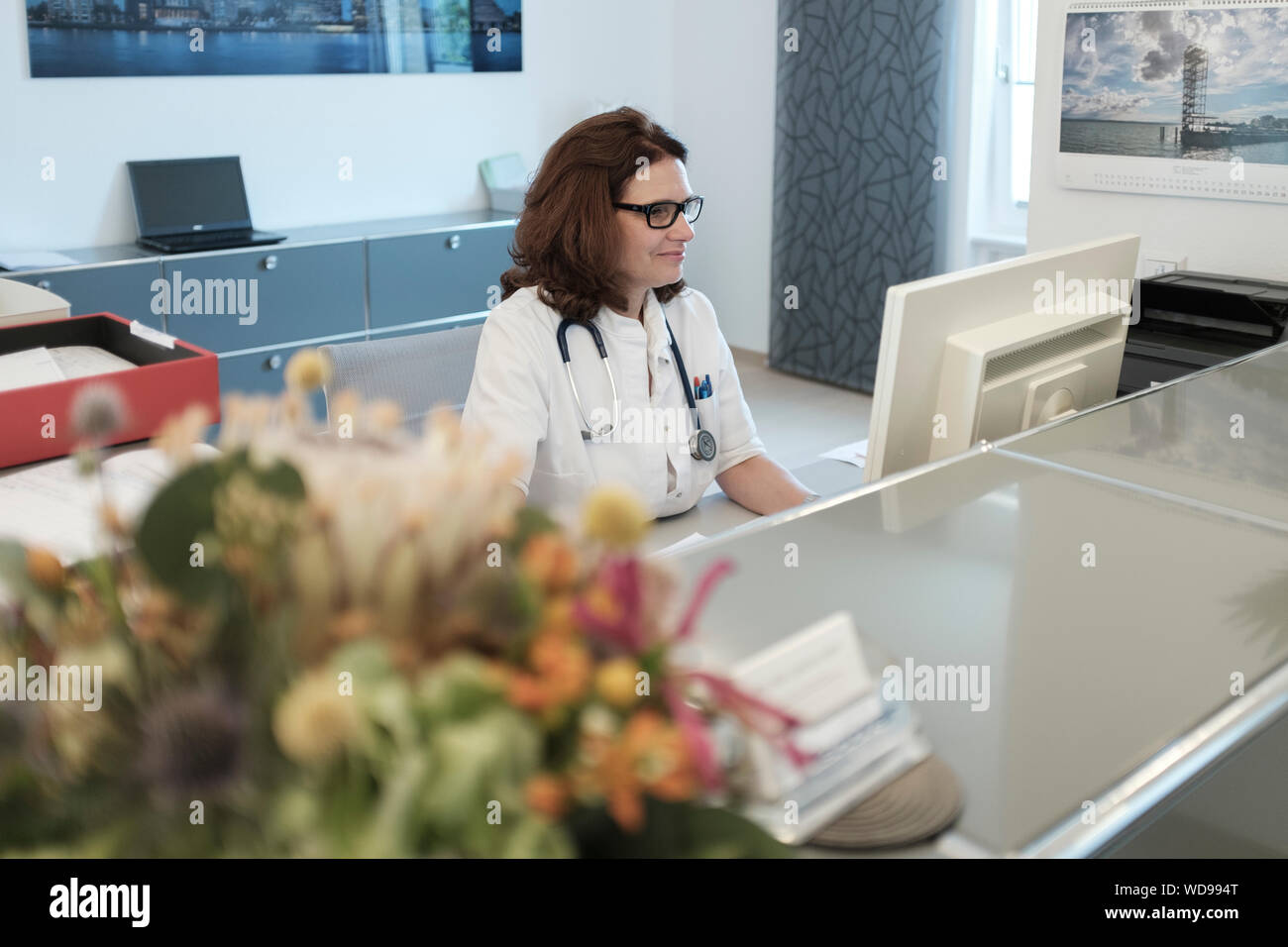Medico donna controlli pianificazione di appuntamenti presso la reception Foto Stock