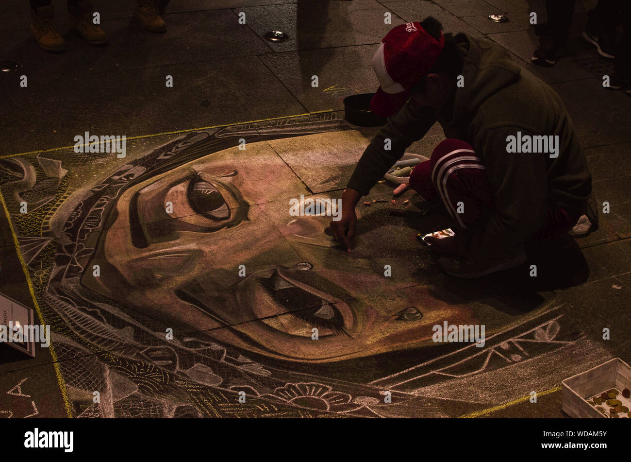 L'artista di strada disegno la Vergine Maria con gessi sul pavimento Foto Stock