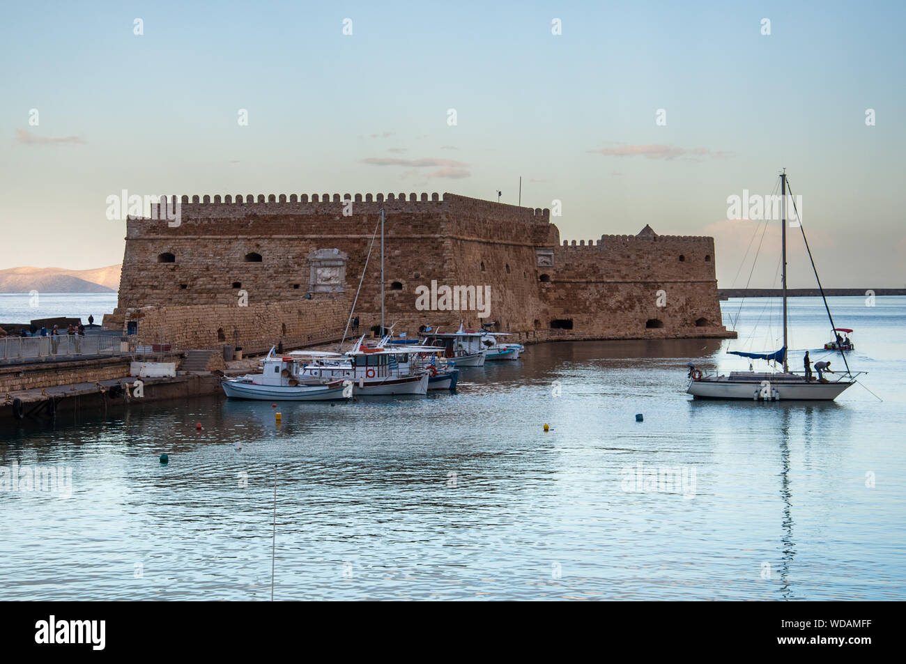 Heraklions fortezza veneziana si erge gaurd alla bocca del porto come il sole tramonta Foto Stock
